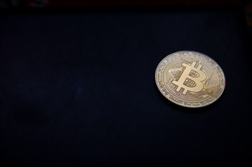 golden bitcoin on a black background with a place for an inscription