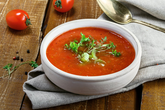 Traditional Spanish gazpacho on a rustic table. Delicious vegan cold tomato soup.