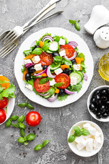 Greek salad. Fresh vegetable salad with tomato, onion, cucumbers, basil, pepper, olives, lettuce and feta cheese. Greek salad on plate