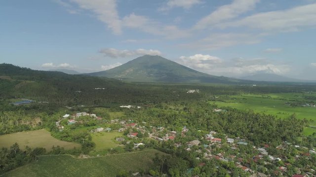 Aerial view of town in a mountain valley at the foot of the mountain Iriga. Luzon, Philippines. Mountainous tropical landscape.