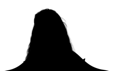 Silhouette Pretty little girl sitting with book and reading track matte