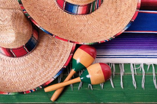 Mexico cinco de mayo fiesta carnival traditional green wood mexican sombrero maracas and serape rug or blanket photo