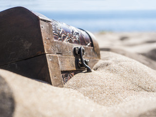 close up locked chest in the sand on the beach