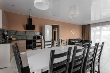 dining table for ten people. Modern minimalism style drawing-room interior. Simple and inexpensive living room with kitchen. daylight in the morning