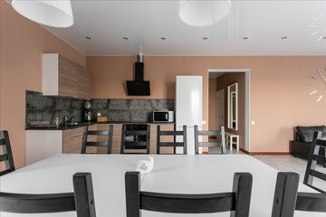 dining table for ten people. Modern minimalism style drawing-room interior. Simple and inexpensive living room with kitchen. daylight in the morning