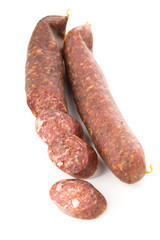 German specialty salami hard cured sausage whole and sliced over white