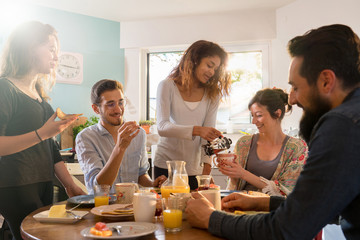 Group of multi-ethnic friends gathered around a table for breakf
