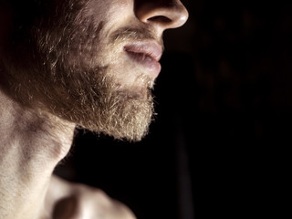 close up portrait of young man with beard on a dark background