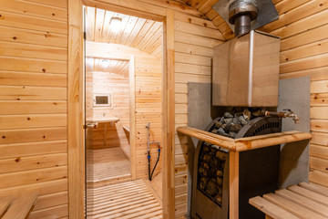 Fototapeta na wymiar interior of sauna. rural mobile wooden bath in the form of a barrel in a pine forest
