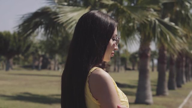 beautiful girl walks on a palm tree