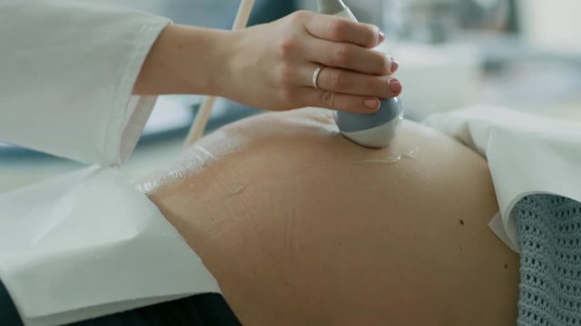 In the Hospital, Close-up Shot of the Doctor Doing Ultrasound / Sonogram Scan to a Pregnant Woman