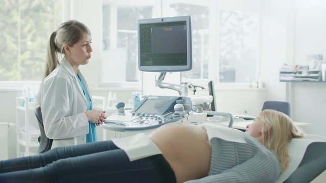 In the Hospital, Pregnant Woman Getting Ultrasound / Sonogram Scan, Obstetrician Explains Procedure. Happy Woman Waiting for their First Baby. Shot on RED EPIC-W 8K Helium Cinema Camera.