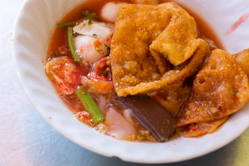 Noodles with fishballs and crispy wonton in red sauce