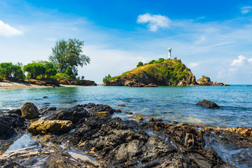 The lighthouse and rocky sand beach with blue sky and daylight on Koh Lanta.