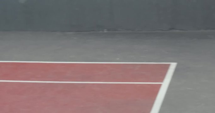 Adult Caucasian male practicing playing tennis on a outdoor hardcourt. 4K UHD 60 FPS SLO MO