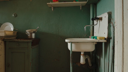 Dripping faucet in an old kitchen of a communal flat
