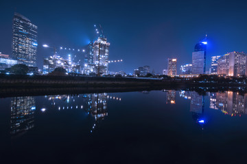 Fototapeta premium Beautiful reservoir with glow lights on skyscrapers