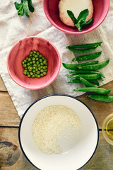 top view raw ingredients cooking vegetable risotto green peas mint goat cheese wooden rustic table Healthy food concept