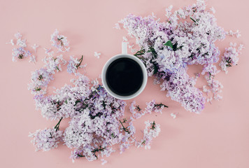 Top view spring minimal concept Flat lay branches lilac flowers cup coffee pink background