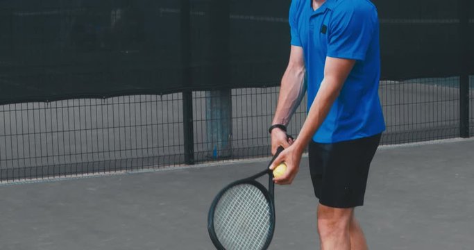 Adult Caucasian male misses the ball while practicing tennis serve on a outdoor hardcourt. 4K UHD 60 FPS SLO MO