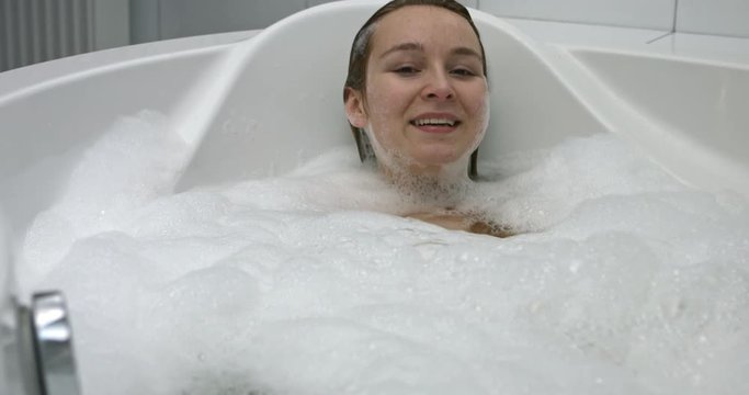 Woman taking bath in bathtub at bathroom