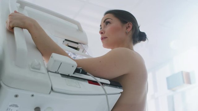 In the Hospital, Low Angle Portrait Shot of Topless Female Patient Undergoing Mammogram Screening Procedure. Shot on RED EPIC-W 8K Helium Cinema Camera.