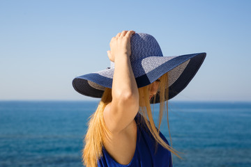 Fototapeta premium Pretty blond woman in the blue dress at the beach in Cyprus.