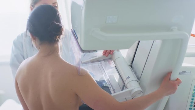 In the Hospital, Back View Shot of Topless Female Patient Undergoing Mammogram Screening Procedure. Shot on RED EPIC-W 8K Helium Cinema Camera.