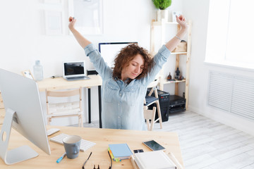 Overworked professional young female worker tired of sitting on one place, has fatigue expression release tension after long working hours in office