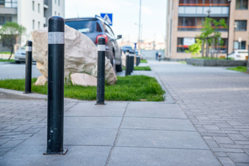 Obraz premium Bollards separating the roadway from the sidewalk in a residential area.