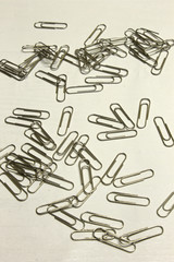 Silver Paper Clips isolated on a textured White background