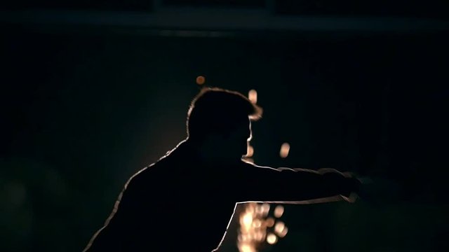 Tricking sport - man performs acrobatic kick in front of bright sparkles - slow-motion