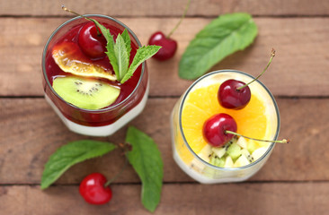 two glasses of Panna cotta dessert with cherries, orange and mint