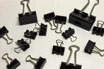 Obraz premium Black Binder clips isolated on a textured White background