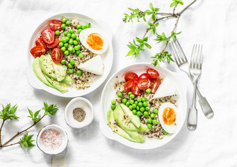 Savory  breakfast grain bowl. Balanced buddha bowl with quinoa, egg, avocado, tomato, green pea on light background. Healthy diet food concept. Top view, flat lay