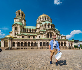 Young caucasian man takes pictures to Alexander Nevsky cathedral in Sofia, Bulgaria. Solo traveler concept.