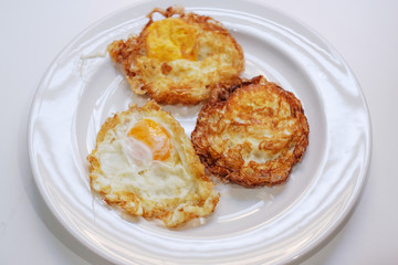 Three fried eggs on white plate and selective focus