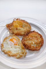 Three fried eggs on white plate and selective focus