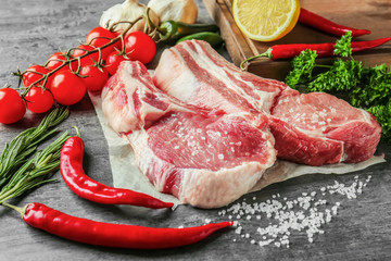 Fresh raw pork ribs with spices and vegetables on kitchen table