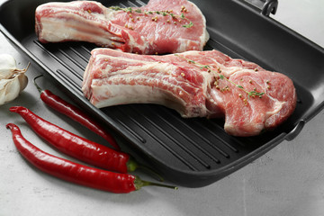 Grill pan with fresh raw pork ribs on kitchen table