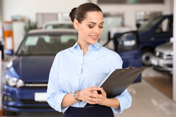 Fototapeta na wymiar Portrait of young saleswoman in car dealership