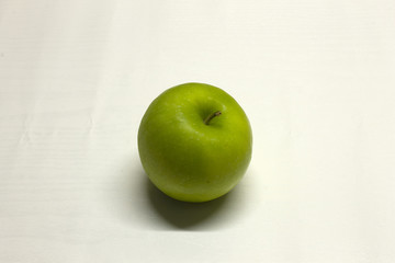 Green Apple isolated on a White textured background with a dark shadow