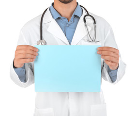 Male doctor holding blank sheet of paper on white background