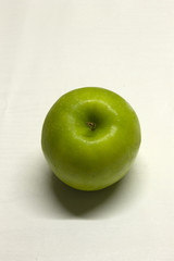 Green Apple isolated on a White textured background with a dark shadow