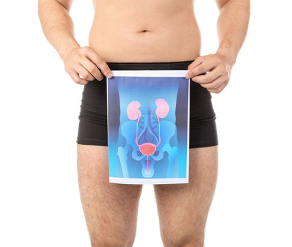 Young man holding picture of urinary system on white background