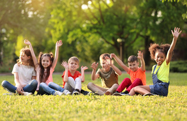 Cute little children sitting on grass outdoors on sunny day © New Africa