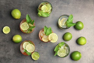 Flat lay composition with mint julep cocktail in glasses on grey background