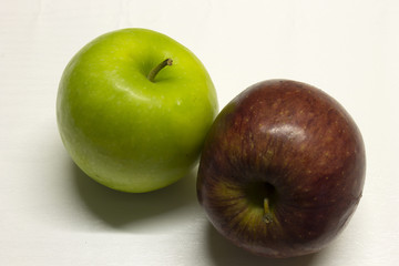Green and Red Apples isolated on a White textured background with a dark shadow