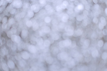 Silver sparkling lights. Glitter festive texture. Abstract background Christmas. Bokeh and stars. Winter card or invitation.