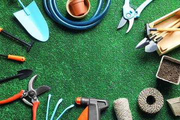 Flat lay composition with professional gardening tools on artificial grass